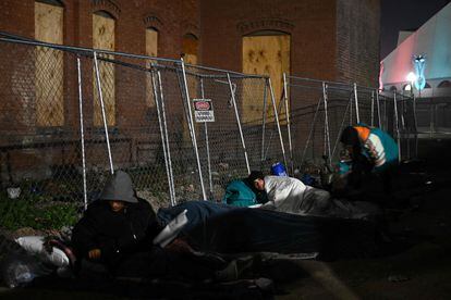 Migrants camp out at night in freezing temperatures in downtown El Paso near a bus station.