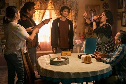 ‘Blue Beetle,’ played by Xolo Maridueña, surrounded by his Mexican family. Their relationship and culture are an essential part of the story. 