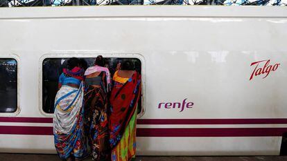 Women peeking inside a Talgo train in Mumbai.