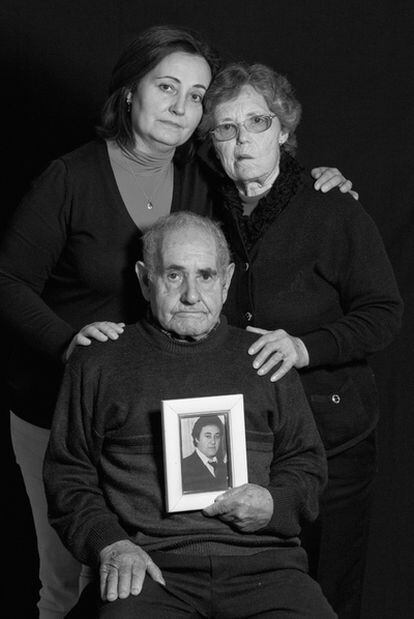 The parents and sister of ETA murder victim Juan Garcia Jiménez pose together with his photo.