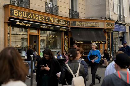 People walk past the "Modern bakery", Place de d'Estrapade, in Paris