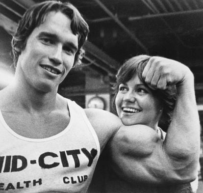 A young Arnold Schwarzenegger shows off his muscles to actress Sally Field, in an image taken in 1976.
