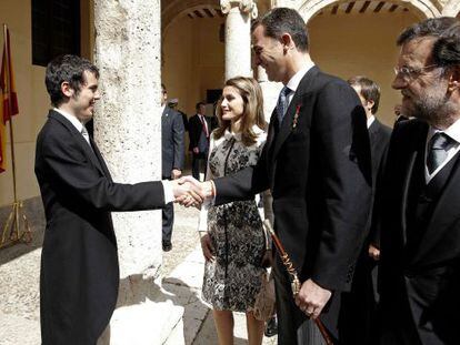 The princes of Asturias and Prime Minister Mariano Rajoy greet Nicanor Parra&#039;s grandson, Crist&oacute;bal Ugarte.