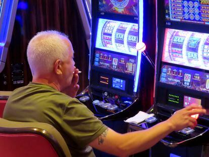 A gambler smokes while playing a slot machine at the Hard Rock casino in Atlantic City N.J. on Aug. 8, 2022.