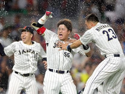 Munetaka Murakami #55 of Team Japan celebrates with teammates after hitting a two-run double to defeat Team Mexico
