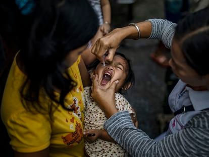 A girl receives the polio vaccine in the Philippines in 2019.