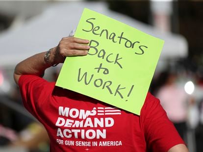 An attendee holds a sign behind their head during a rally calling for an end to the Senate Republican walkout at the Oregon State Capitol in Salem, Ore., Thursday, May 11, 2023.