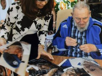 Cuba&#039;s former President Fidel Castro signs pictures for Argentinian President Cristina Fern&aacute;ndez de Kirchner in Havana in this handout image.