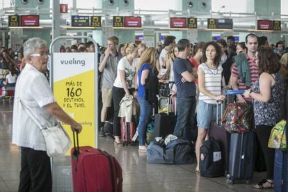 Passengers lining up at Vueling counters at Barcelona airport.