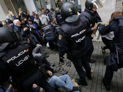 Police break up a group of voters on October 1 in Barcelona.