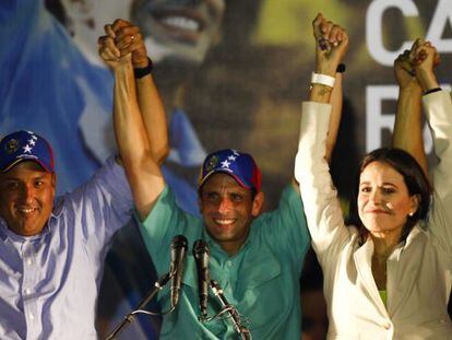 Presidential candidate Henrique Capriles raises his hands with Zulia state governor Pedro P&eacute;rez and independent candidate Mar&iacute;a Corina Machado in Caracas on Sunday. 