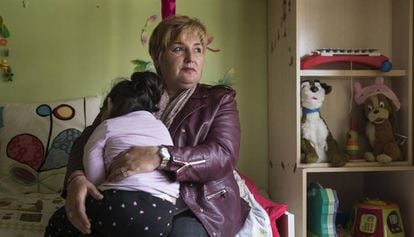 Justi Carretero holds her foster daughter in her house in Guadalajara.