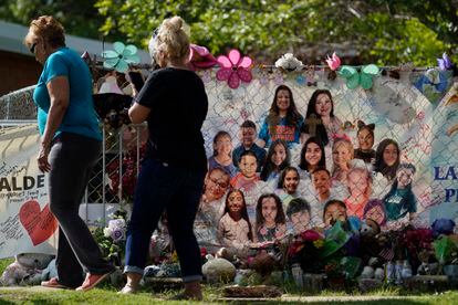 Robb Elementary was permanently closed after the massacre that claimed the lives of 19 students and two teachers on May 24. Pictured above, two women walk past the makeshift memorial outside Robb Elementary.