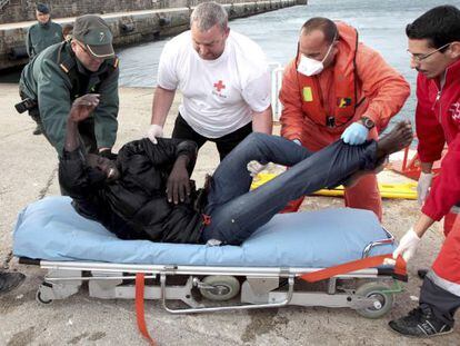 Emergency workers place one of the rescued immigrants on a stretcher. 