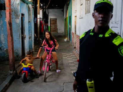 Children play and a police officer stands guard in the neighborhood of La Inmaculada.