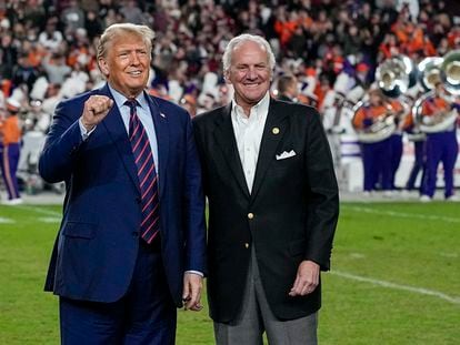 Republican presidential candidate and former President Donald Trump gestures with South Carolina Gov. Henry McMaster during halftime in an NCAA college football game between the University of South Carolina and Clemson Saturday, Nov. 25, 2023, in Columbia, S.C.