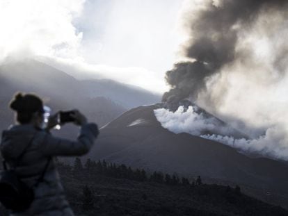 A woman takes a photo of the new volcano on La Palma.