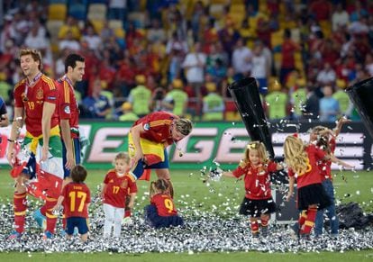 Spain players Llorente, Busquets and Torres (l to r) in Kiev after the final together with various squad-connected children.