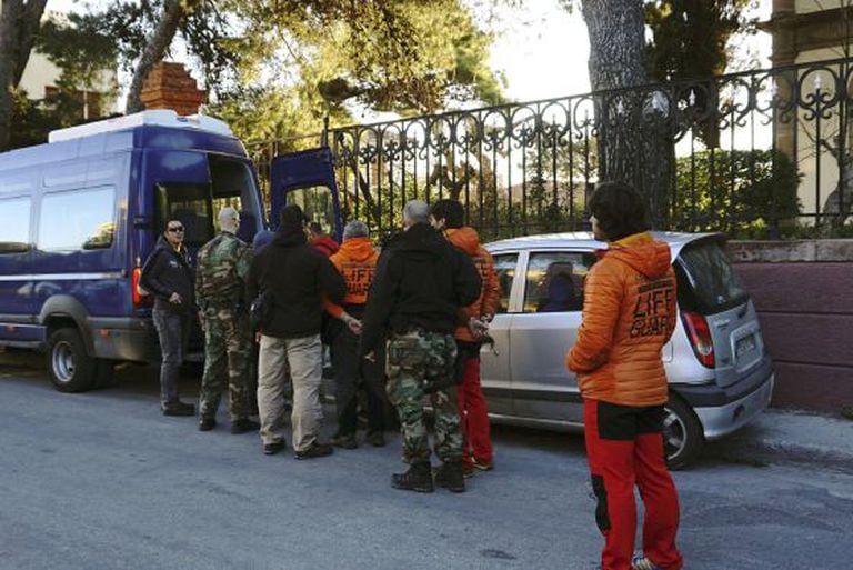 Greek officers lead Spanish volunteers from Proem-aid to a police van following their arrest with two Danish nationals in the Aegean Sea.