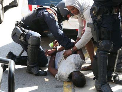 Catalan officers arrest a man following a riot in Salou.