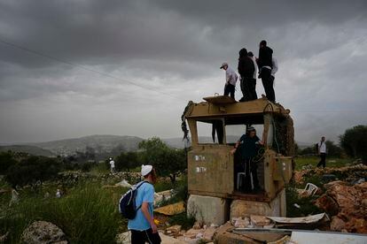 Israeli settlers stand in the outpost of Eviatar in the West Bank, Monday, April 10, 2023