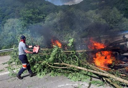 A protester pours fuel onto a flaming roadblock in Pozo Santiago de Aller, Asturias. 