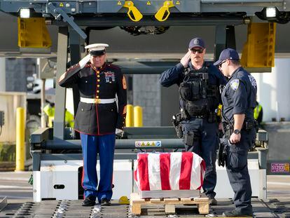 Marine First Sgt. Timothy La Sage, left, and Port Authority police officers salute as the remains of retired Marine Capt. Grady Kurpasi are transferred from a Turkish airlines plane at New York's John F. Kennedy International Airport.