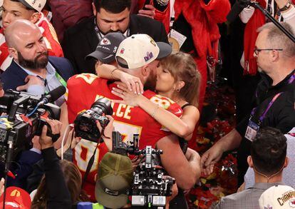 Taylor Swift kisses Travis Kelce after the game.