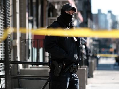 A police officer stands outside a building where two NYPD officers were shot.