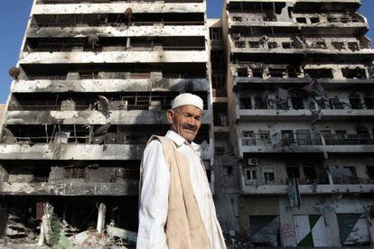 A man stands in front of a bombed-out building in Misrata.