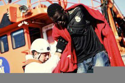 A rescue staff member helps a migrant who has been rescued off the coast of Tarifa.