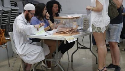 David Franco Portolés checks ID cards at a polling station.