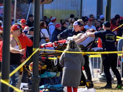 A woman is taken to an ambulance after an incident following the Kansas City Chiefs NFL football Super Bowl celebration in Kansas City, Mo., Wednesday, Feb. 14, 2024.