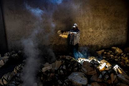 A worker at the Macurichus mezcal production plant bakes agave stalks in Santiago Matatlán, Oaxaca State in Mexico.

