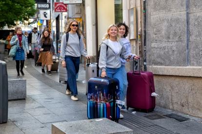 Tourists with suitcases on Carretas street in Madrid.