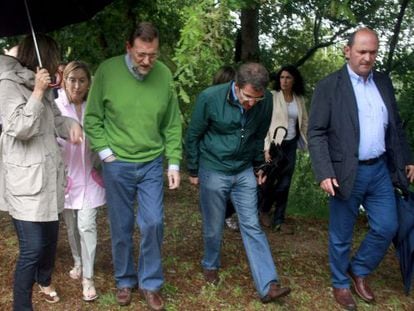 Mariano Rajoy in Galicia on Saturday next to regional premier Alberto N&uacute;&ntilde;ez Feij&oacute;o (stooping).
