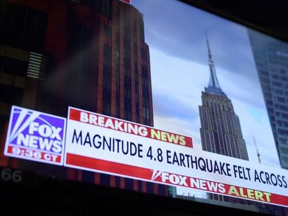 A screen at the New York Stock Exchange shows a news alert of a magnitude 4.8 earthquake in New York City.