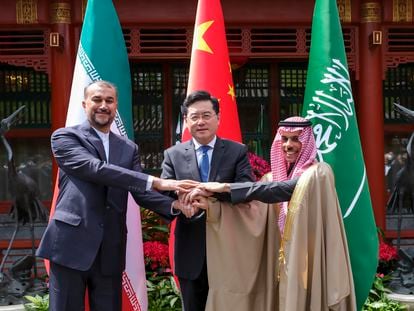 Iran's Foreign Minister Hossein Amirabdollahian, left, hold hands with his Saudi Arabian counterpart Prince Faisal bin Farhan Al Saud, right, and Chinese counterpart Qin Gang in Beijing Thursday, April 6, 2023.