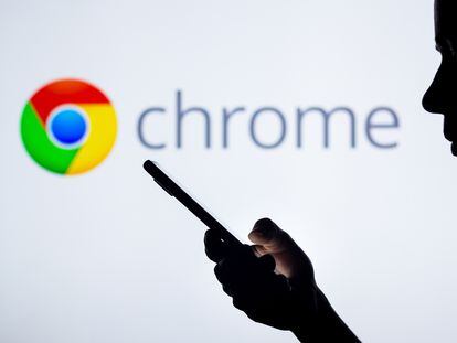 The Google Chrome logo on the background of a silhouette of a woman holding a mobile phone.
