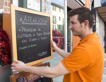 An café employee puts up a sign warning customers of the ban.