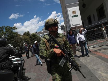 A soldier stands guard in the main square in central Quito ahead of Sunday's presidential elections.