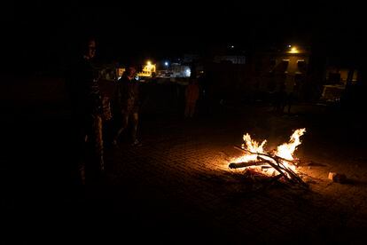 A night outdoors in Mulay Brahim. Young men warm themselves at a bonfire. 