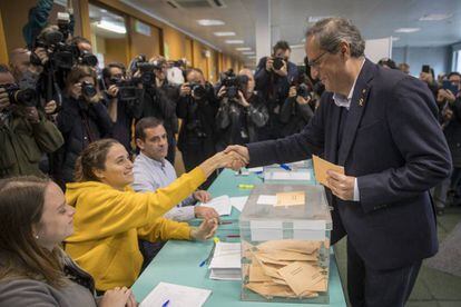 Catalan premier Quim Torra votes and shakes hands with his daughter, who was serving as a voting official.