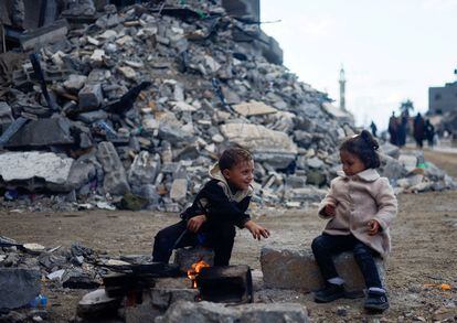 Two children play on a street in Khan Younis, surrounded by buildings destroyed by Israeli attacks, November 27.