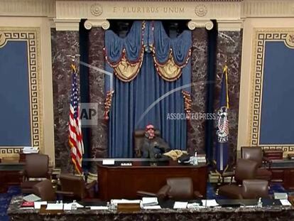 This image from U.S. Senate video shows Bruno Joseph Cua sitting with his feet up in the Senate chamber on Jan. 6, 2021, during the riot at the U.S. Capitol.