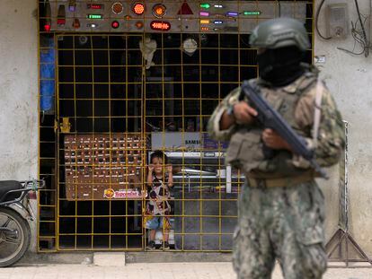 A child looks through a grille at a soldier stationed on the street in Guayaquil, Ecuador.