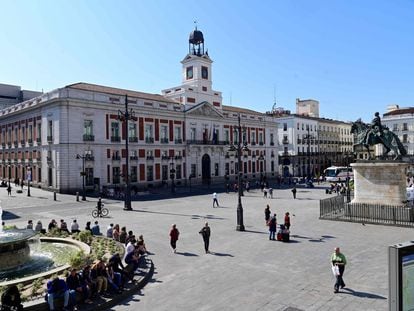 Several people walk through the usually crowded Puerta del Sol in central Madrid on March 14 after regional authorities ordered all stores in the region to be closed.