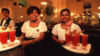 Waitresses serving Singapore Sling cockktails at the Raffles Hotel in Singapore.