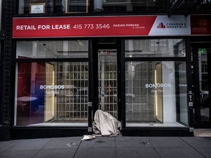 A homeless man rests in the doorway of an empty commercial space in downtown San Francisco.