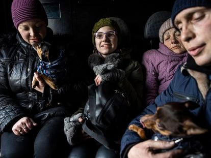 Arina, center, rides inside a car with her family during an evacuation by Ukrainian police, in Avdiivka, Ukraine, Tuesday, on March 7, 2023.